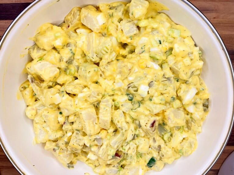 Overhead view of old-fashioned potato salad with cooked dressing made with potatoes, eggs, celery, dill pickle, and green onion