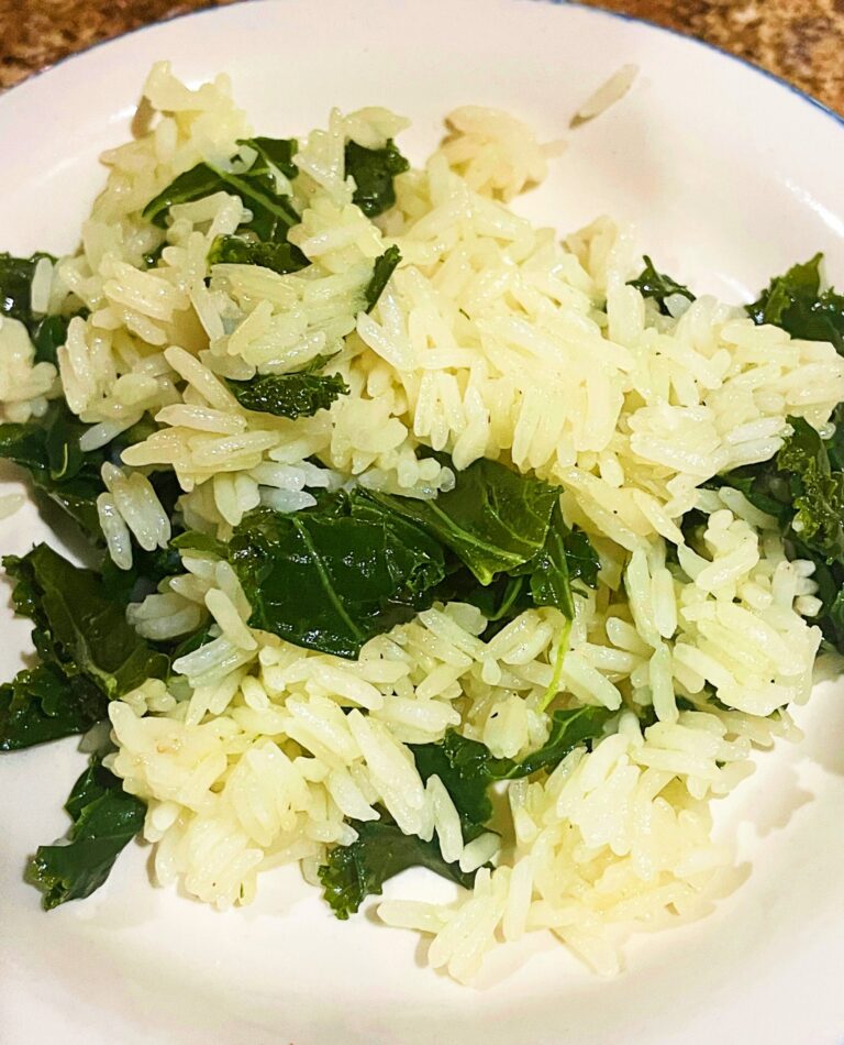garlic butter rice with kale on a white plate
