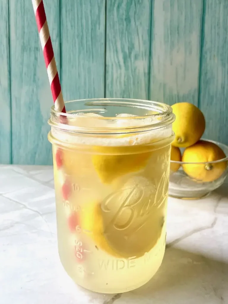 a mason jar filled with refreshing state fair lemonade with a red and white striped straw