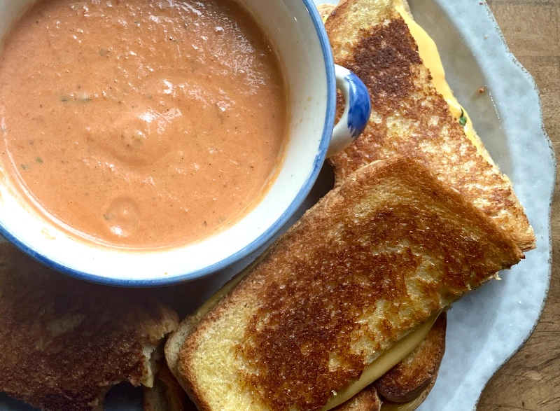 Easy Creamy Roasted Tomato Soup made with fresh garden tomatoes, onion, and garlic. A cozy, comforting soup perfect for summer harvest or chilly fall nights. Pin this recipe for delicious homemade soup to warm up with!