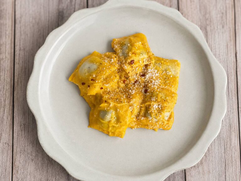 creamy butternut squash ravioli on a white plate