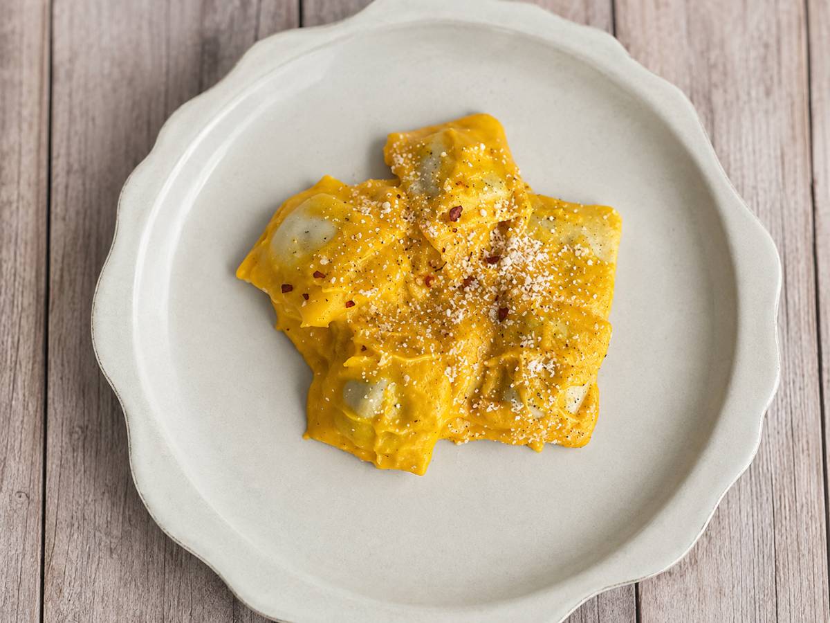 creamy butternut squash ravioli on a white plate