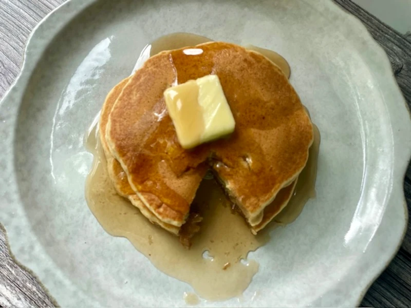 plate of apple spice pancakes with syrup and butter