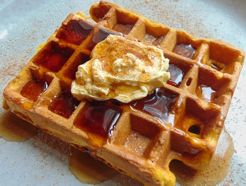 Pumpkin Chai Waffles - waffle on a plate with butter and maple syrup