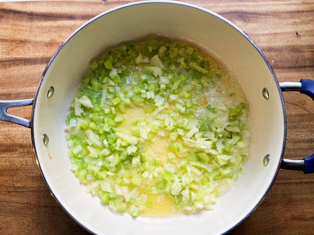 a pan with sauteed onion, celery, and garlic for sourdough herb stuffing
