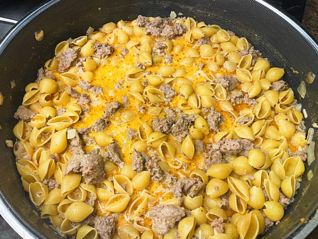 shell pasta added to other ingredients for Creamy Beef and Cheddar Pasta (One Pan Meal)