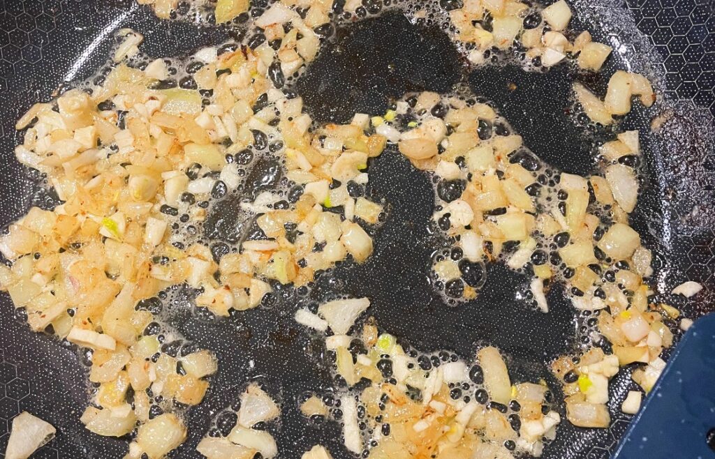 sauted onion and garlic for creamy chicken spinach pasta bake