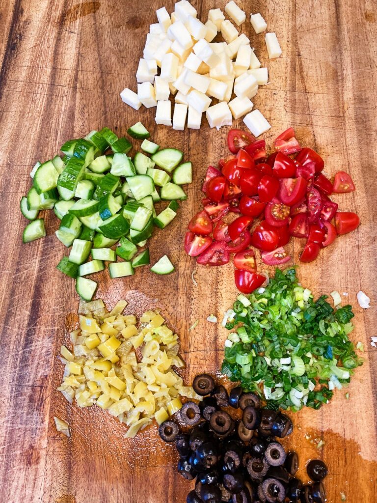 chopped veggies, cheese, and olives for creamy pasta salad