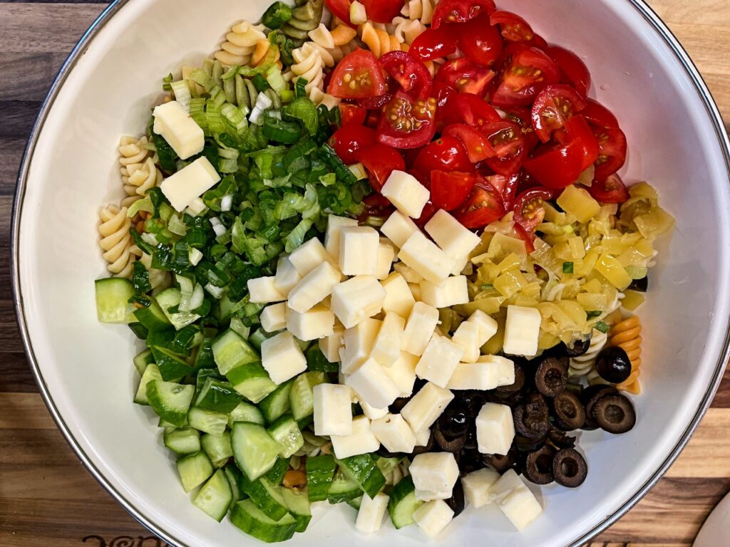 bowl of pasta, veggies, olives and cheese for creamy pasta salad