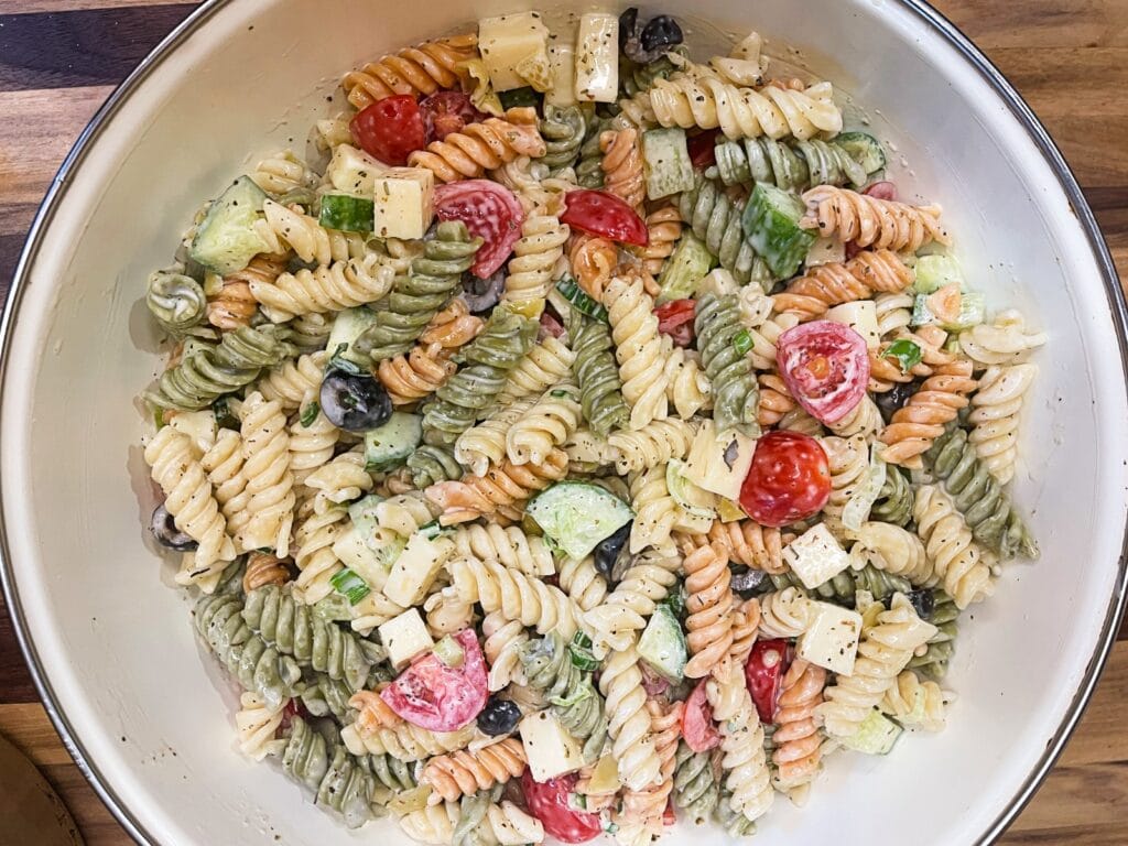 Overhead view of creamy pasta salad with rotini, chopped vegetables, and creamy dressing