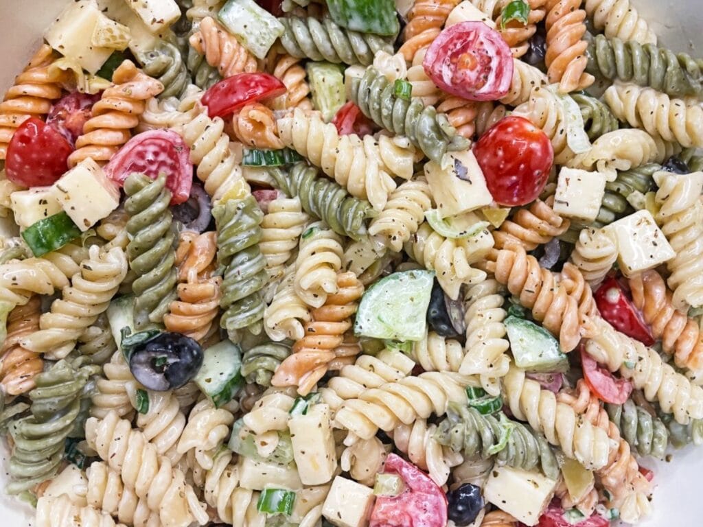 Creamy pasta salad in a serving bowl with homemade dressing, vegetables, and pasta twists