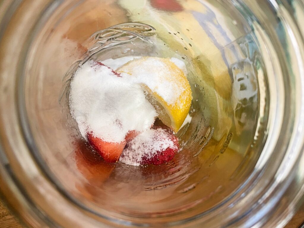 lemon, strawberry and sugar in a jar to be muddled