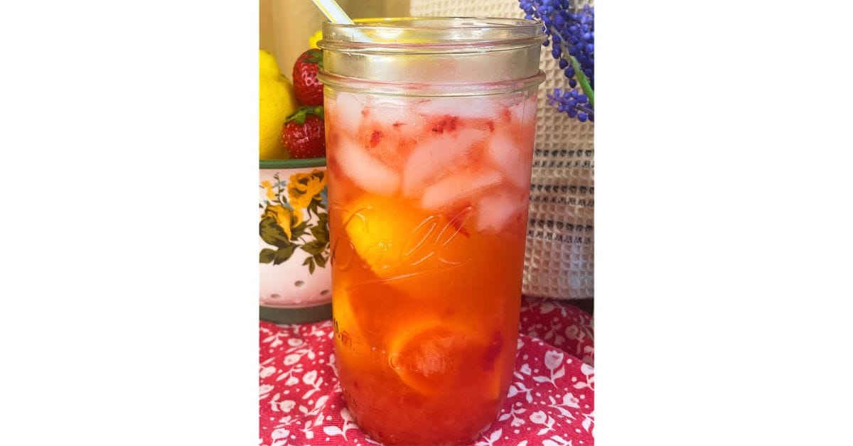 mason jar of strawberry lemonade with ice and a straw