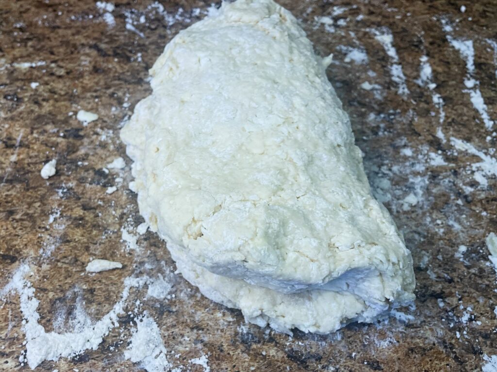 biscuit dough flatten out and folded over itself to create flaky layers 