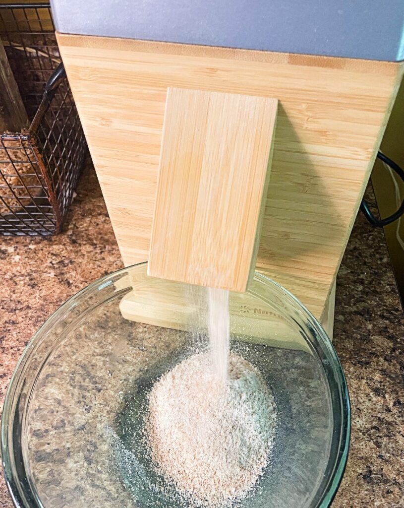 nutrimill flour mill grinding wheat berries into a bowl