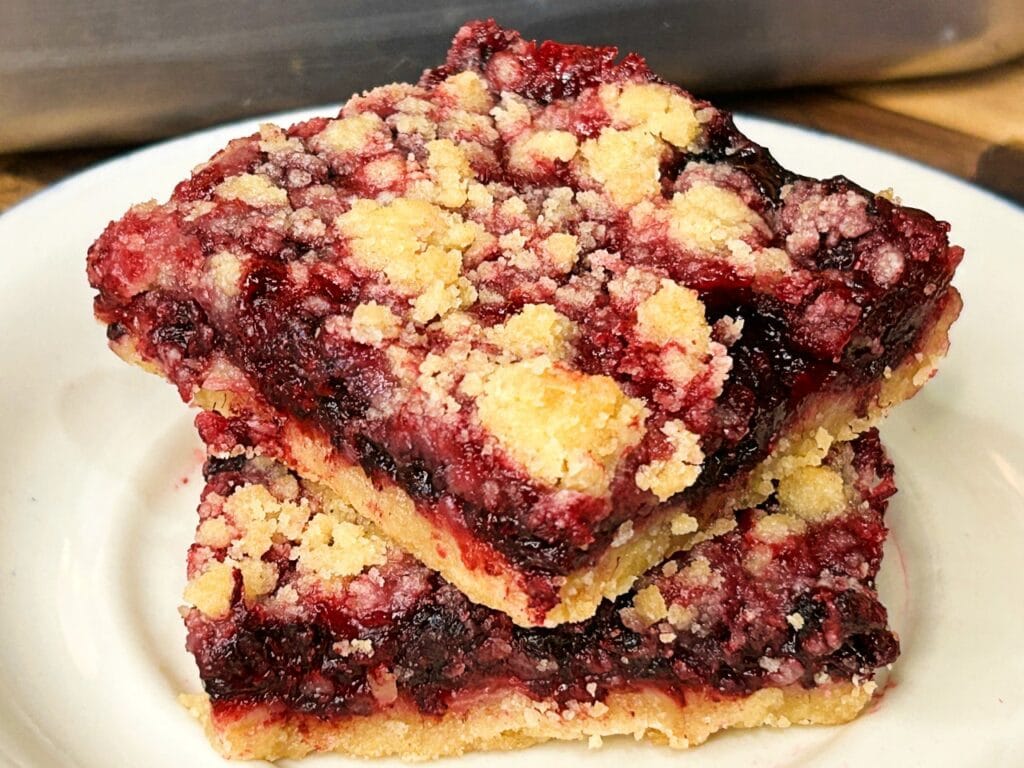 black raspberry crumble bars stacked on a plate