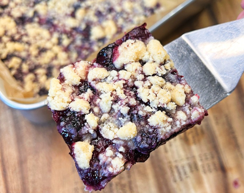 Sliced blueberry crumble bars with jammy blueberry filling and golden crumb topping.