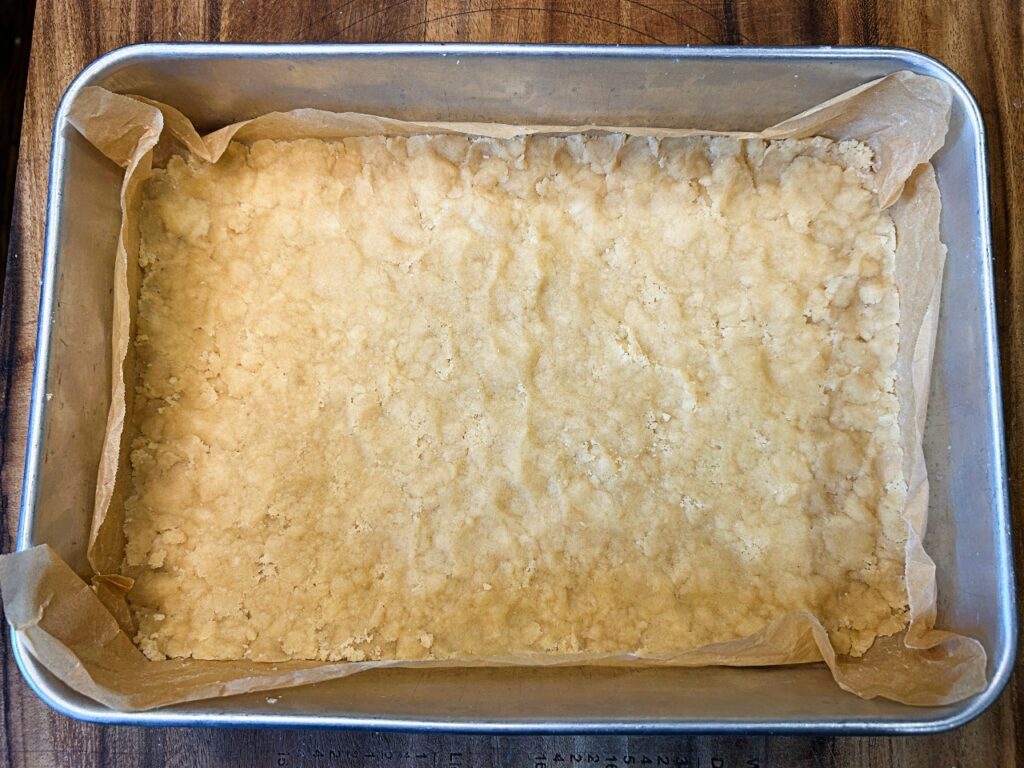 Buttery crumble crust pressed into the bottom of a 9x13 baking dish.