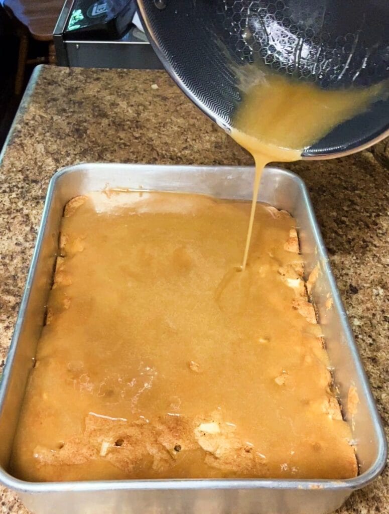Homemade caramel glaze being poured over warm Apple Dapple Cake