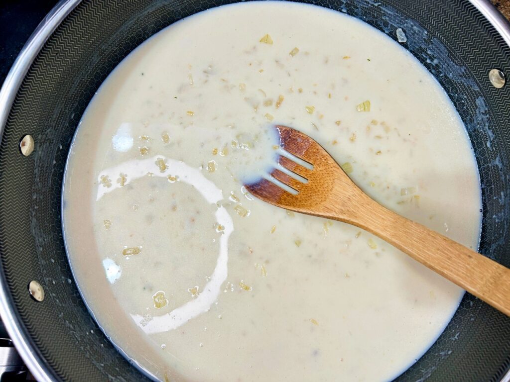 Homemade garlic herb cream sauce simmering in a skillet