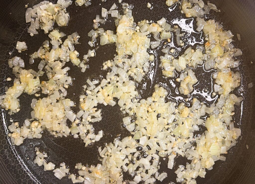 Diced onion and garlic cooking in butter