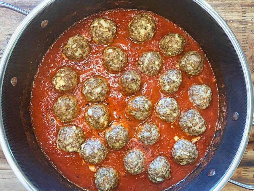 Baked homemade meatballs served with marinara sauce and Parmesan cheese.