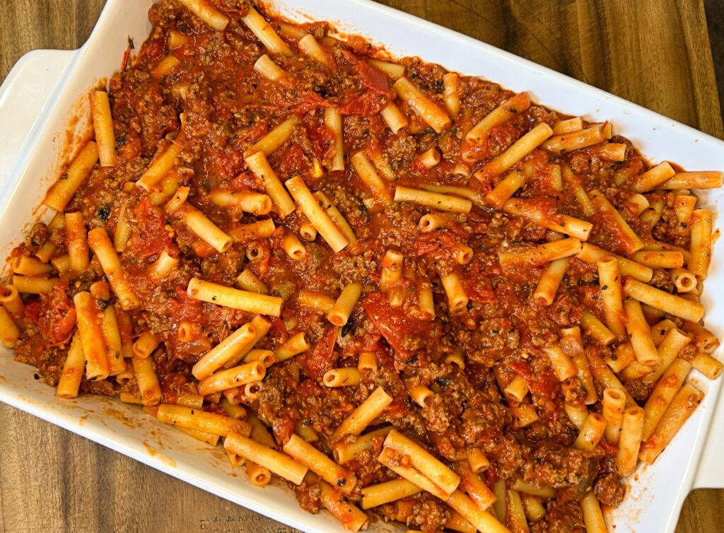 ziti and meat sauce mixture in a baking dish