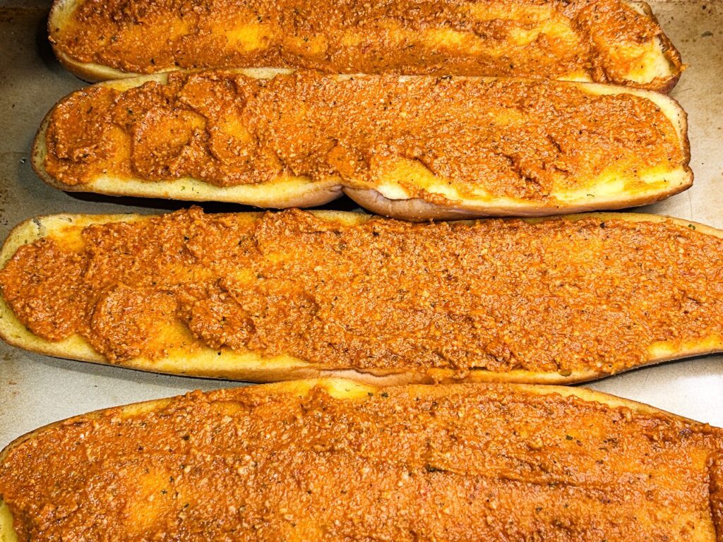 sun dried tomato pesto spread across garlic bread