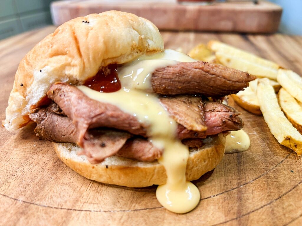 Homemade Beef and Cheddar sandwich with sliced roast beef, cheddar cheese sauce and Arby's-style sauce on an onion roll