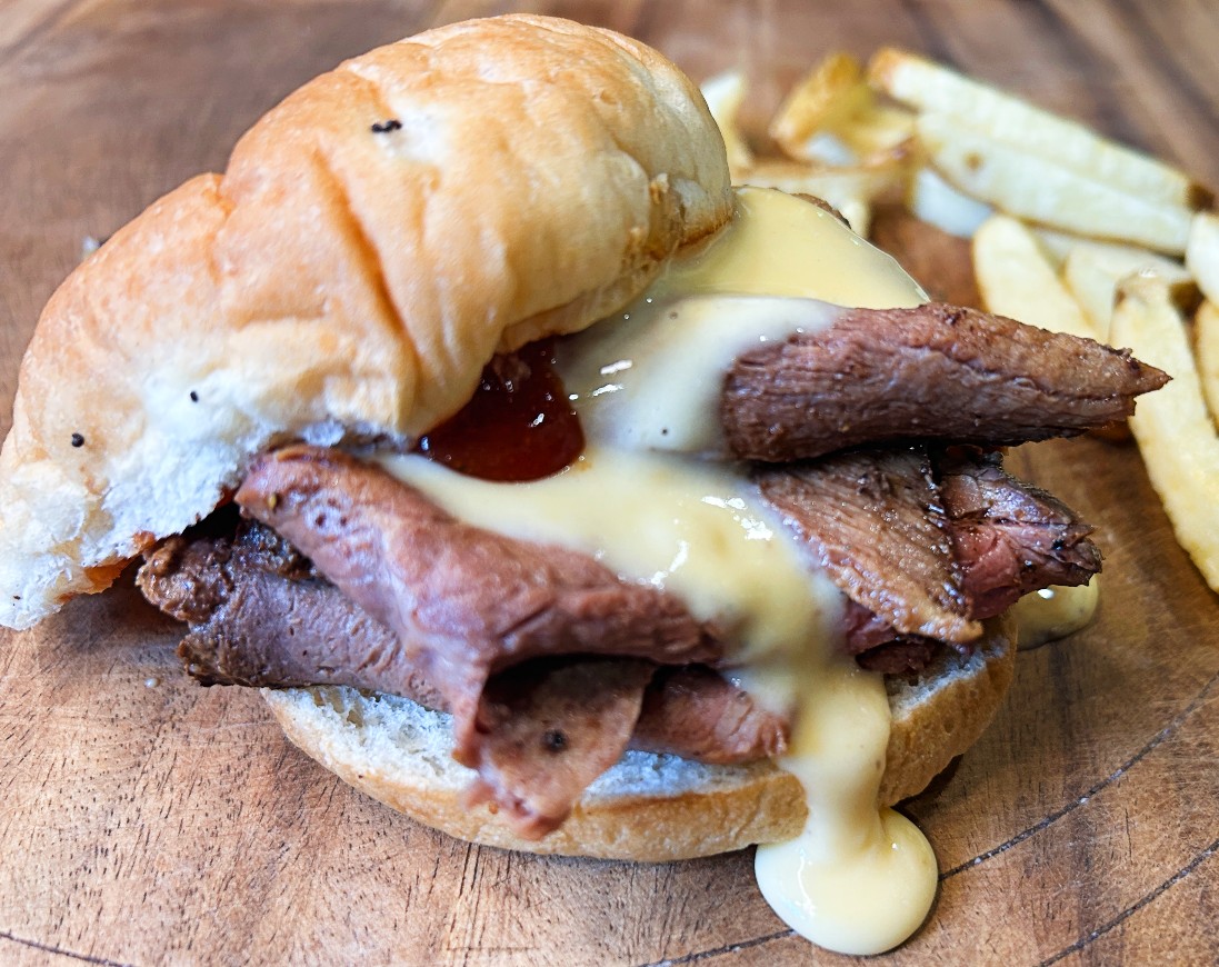 Homemade Beef and Cheddar sandwich with sliced roast beef, cheddar cheese sauce and Arby's-style sauce on an onion roll