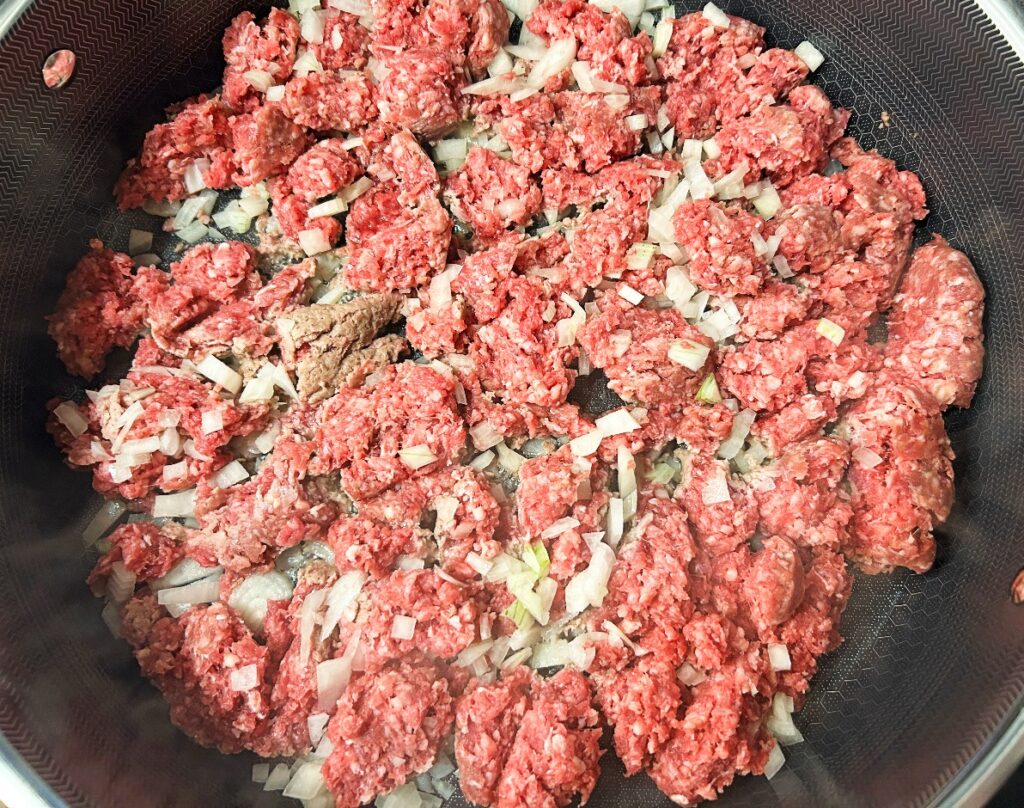 ground beef and onions cooking in a skillet