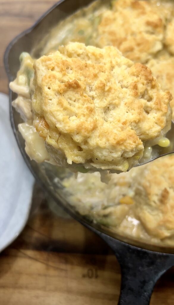 Freshly baked cast iron chicken pot pie with eight golden biscuit toppings.