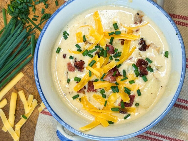 Creamy loaded potato soup topped with crispy bacon, shredded cheddar cheese, and fresh chives