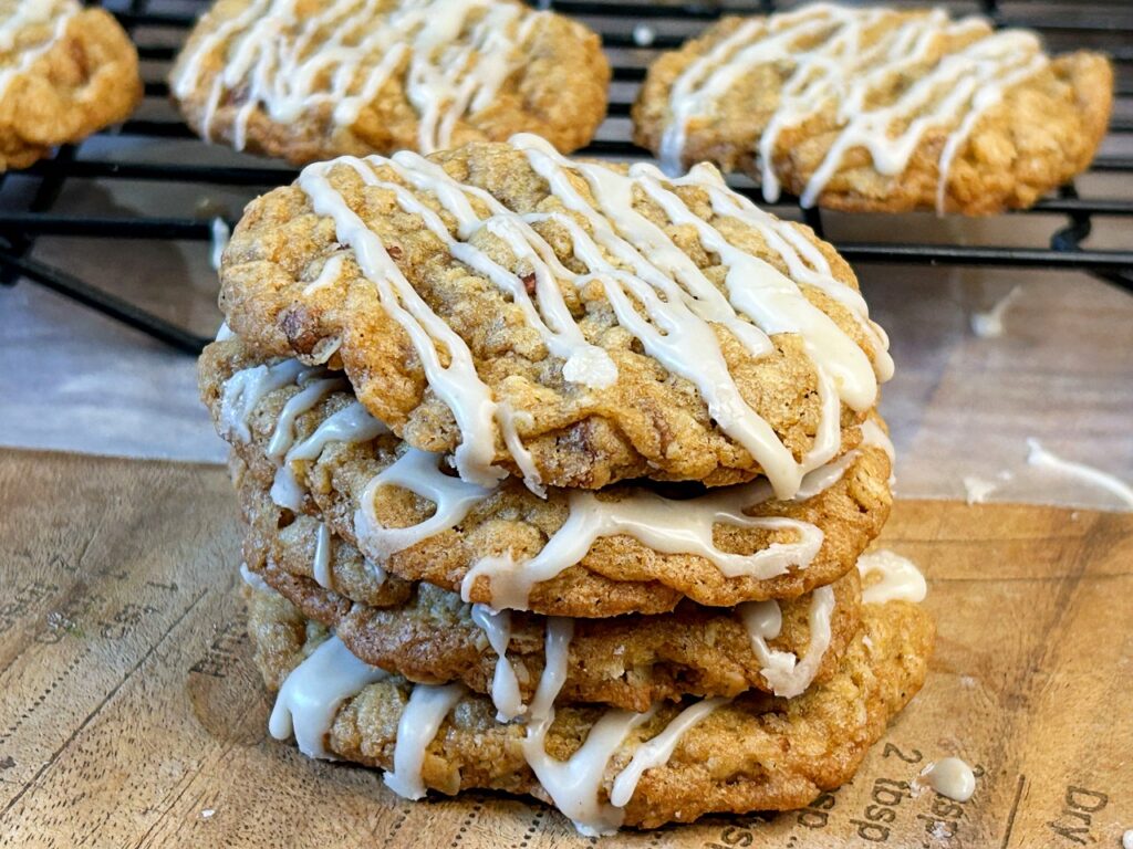 Stack of brown butter maple pecan oatmeal cookies with maple glaze.
